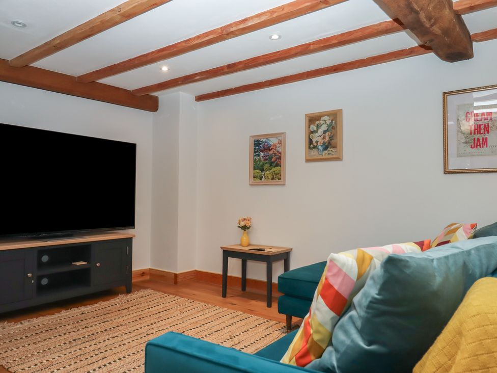 A living room with a television and sofa at Pylemoor Cottage Washfield near Tiverton