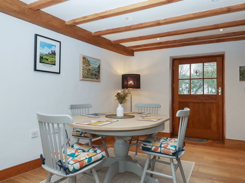 A dining room with a table and chairs at Pylemoor Cottage in Washfield near Tiverton