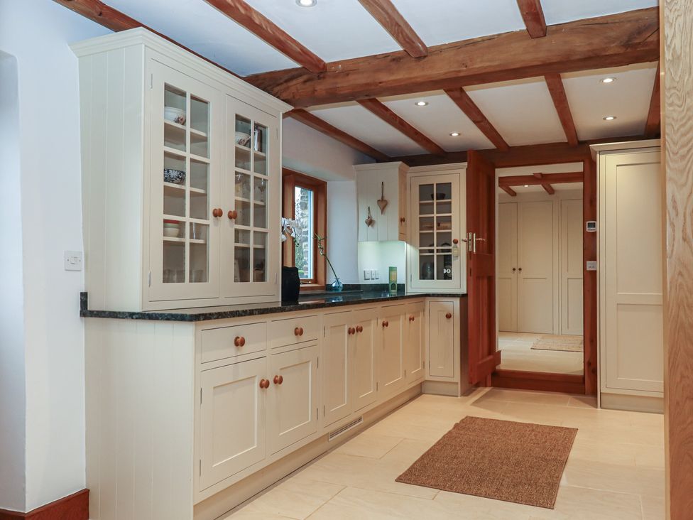 A kitchen with cabinets and countertop at Pylemoor Cottage in Washfield near Tiverton