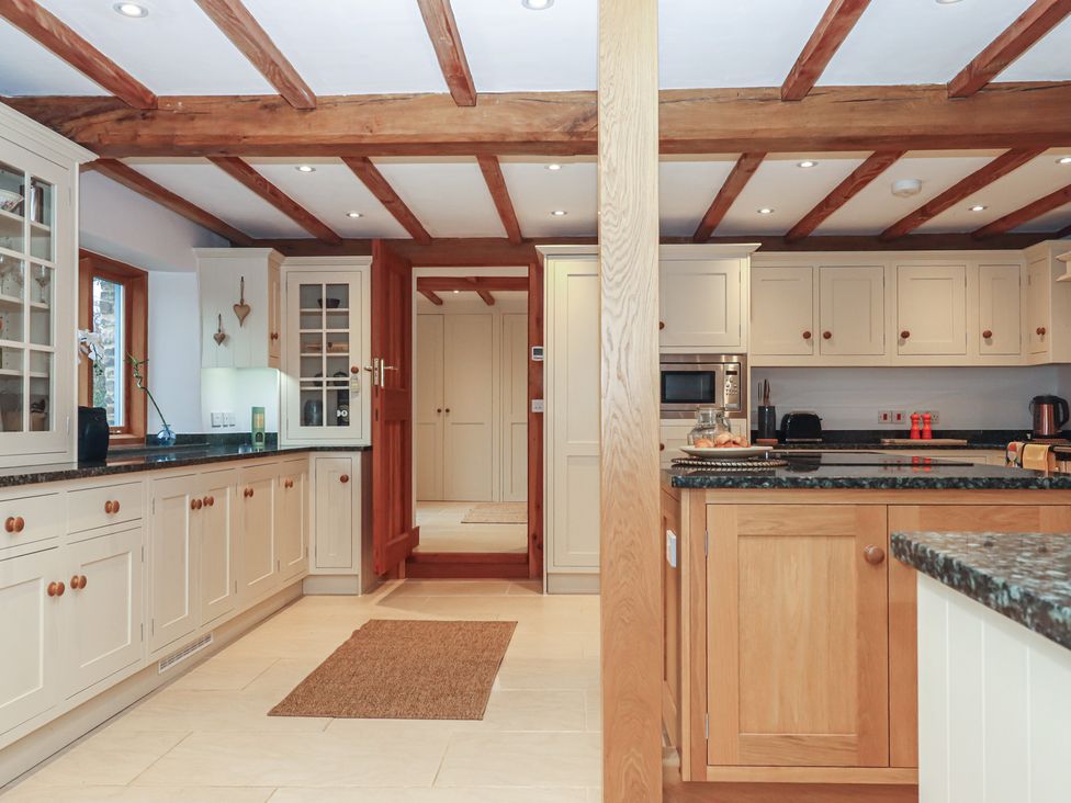 A kitchen with cabinets and appliances at Pylemoor Cottage in Washfield near Tiverton