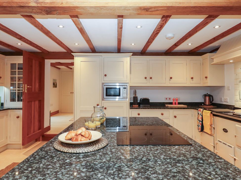 A kitchen with cabinets and appliances at Pylemoor Cottage in Washfield near Tiverton