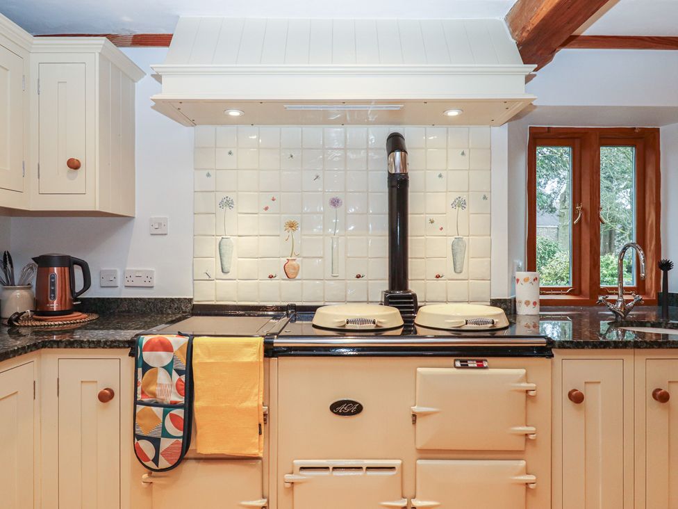A kitchen with a stove and cabinets at Pylemoor Cottage Washfield near Tiverton