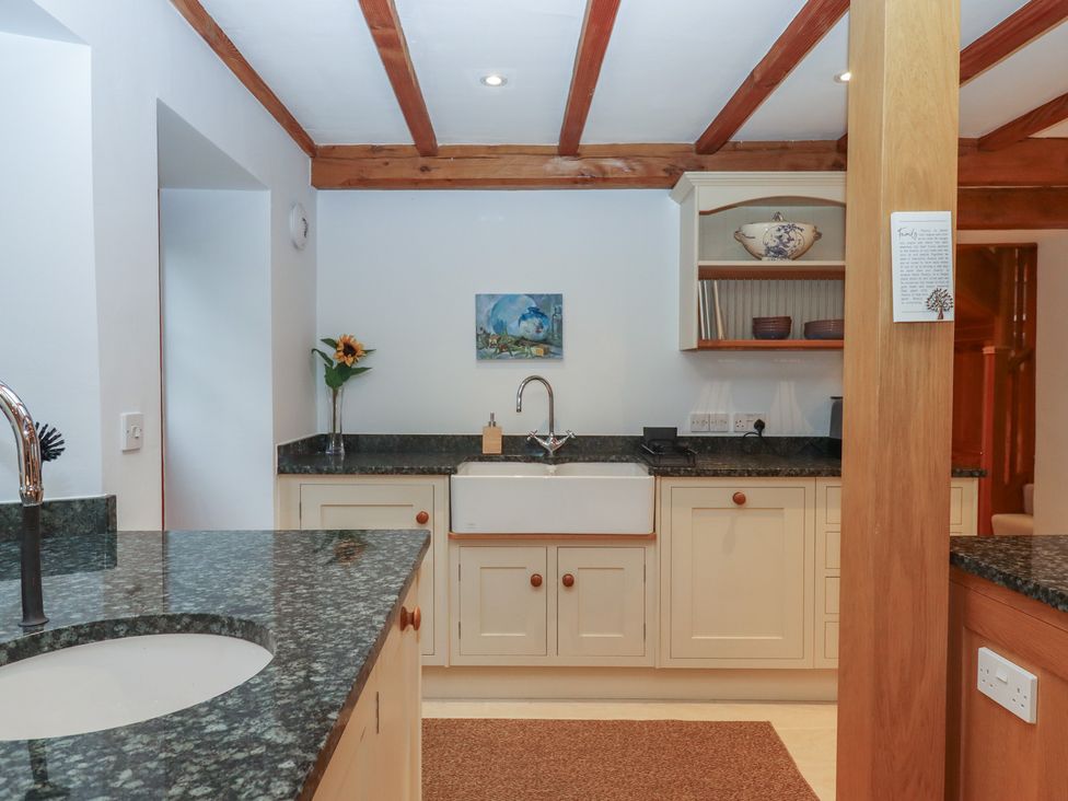 A kitchen with a sink and cabinets at Pylemoor Cottage in Washfield near Tiverton
