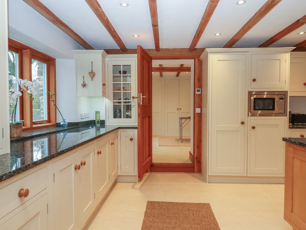 A kitchen with cabinets and a microwave at Pylemoor Cottage Washfield near Tiverton