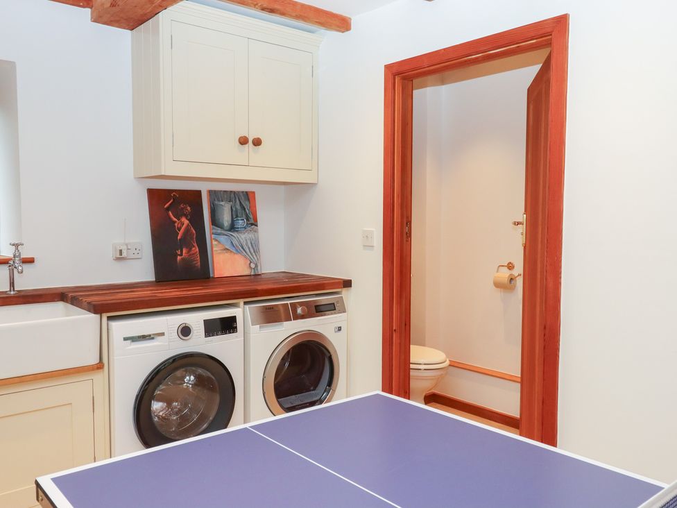 A laundry room with a washing machine and dryer at Pylemoor Cottage Washfield near Tiverton