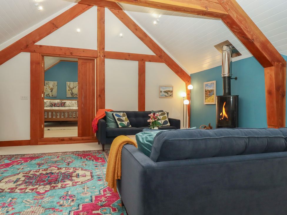 A living room with a sofa and fireplace at Pylemoor Cottage in Washfield near Tiverton