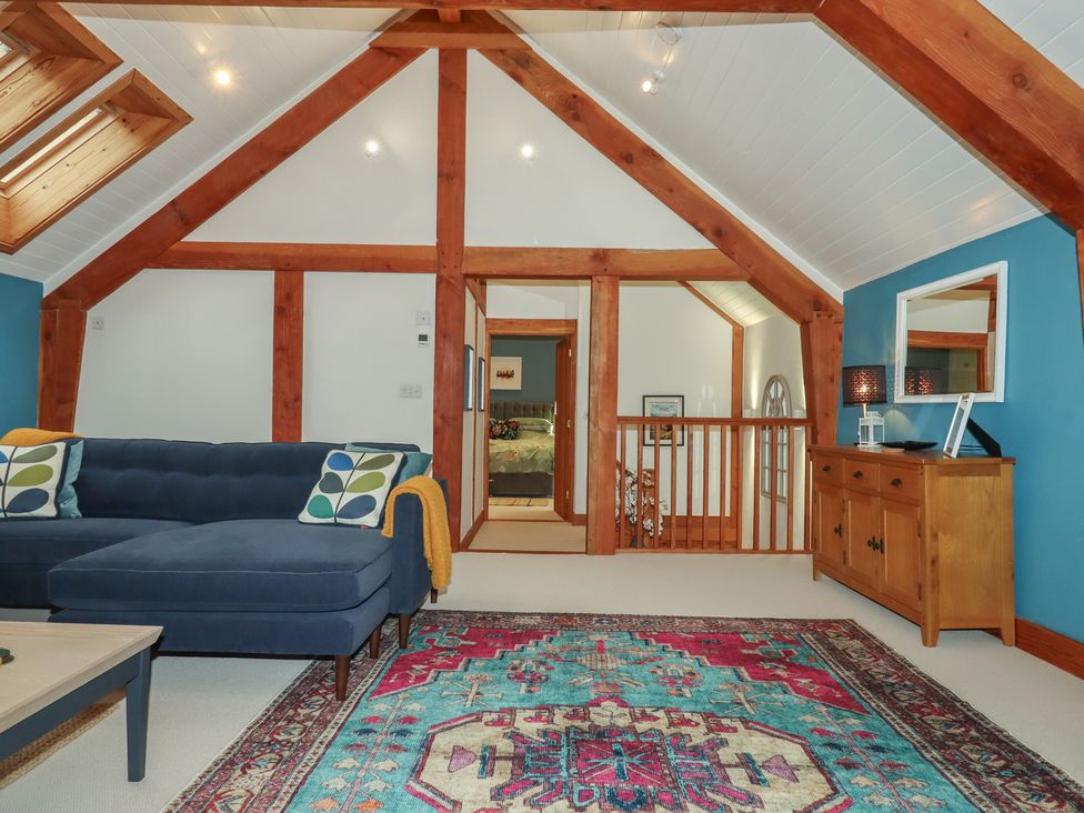 A living room with a sofa and rug at Pylemoor Cottage, Washfield near Tiverton