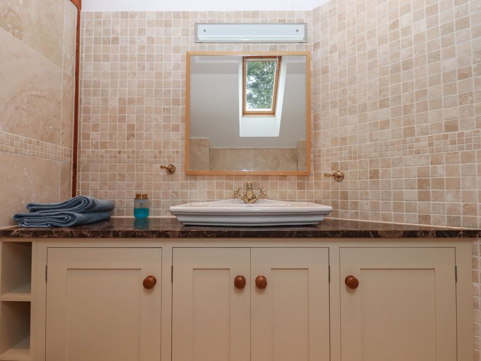 A bathroom with a sink and mirror at Pylemoor Cottage in Washfield near Tiverton