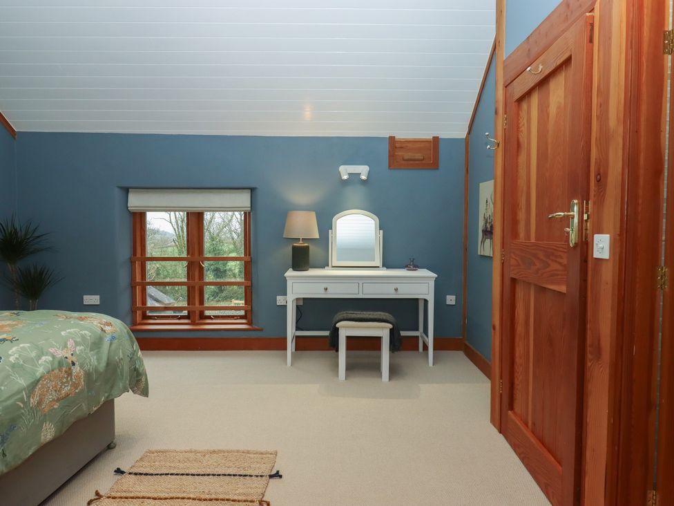 A bedroom with a vanity table and window at Pylemoor Cottage in Washfield near Tiverton