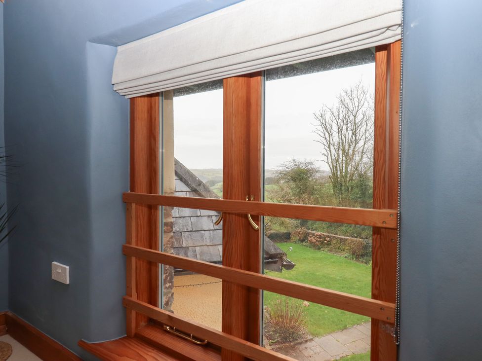 A window with a view of grassy area at Pylemoor Cottage in Washfield near Tiverton