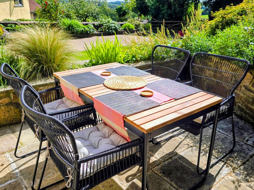 An outdoor dining area with a table and chairs at Pylemoor Cottage in Washfield near Tiverton