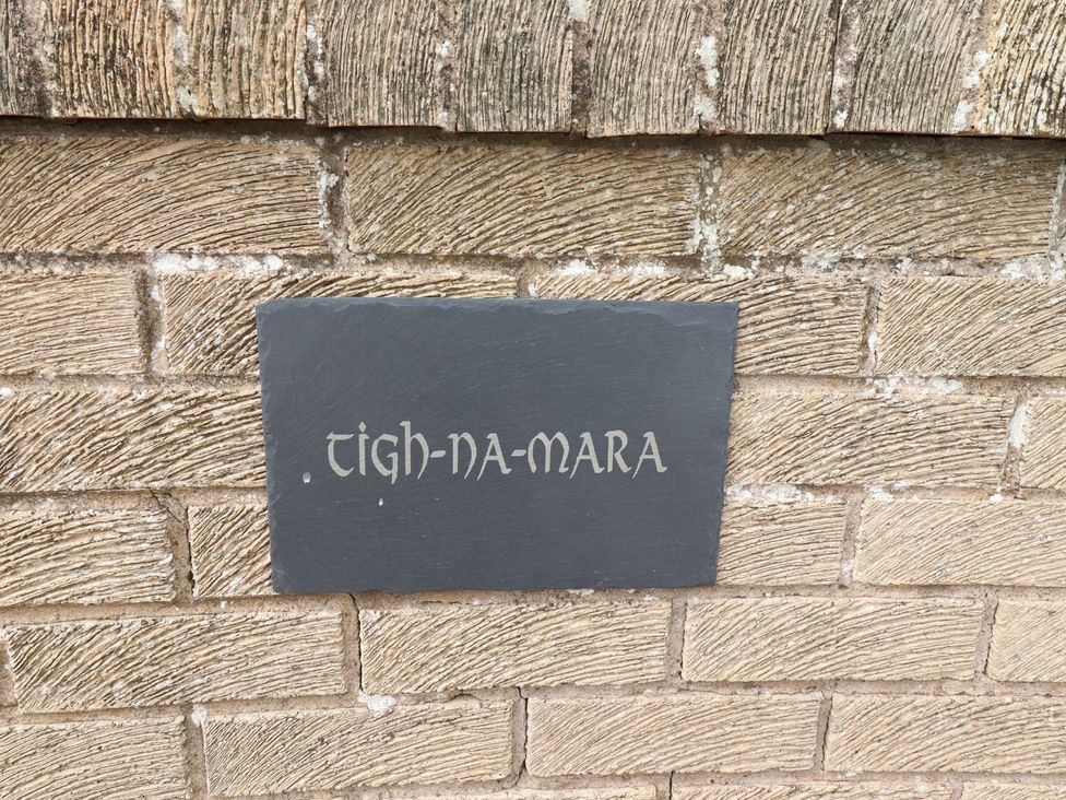 A slate sign with the name Tigh-Na-Mara on a wall
