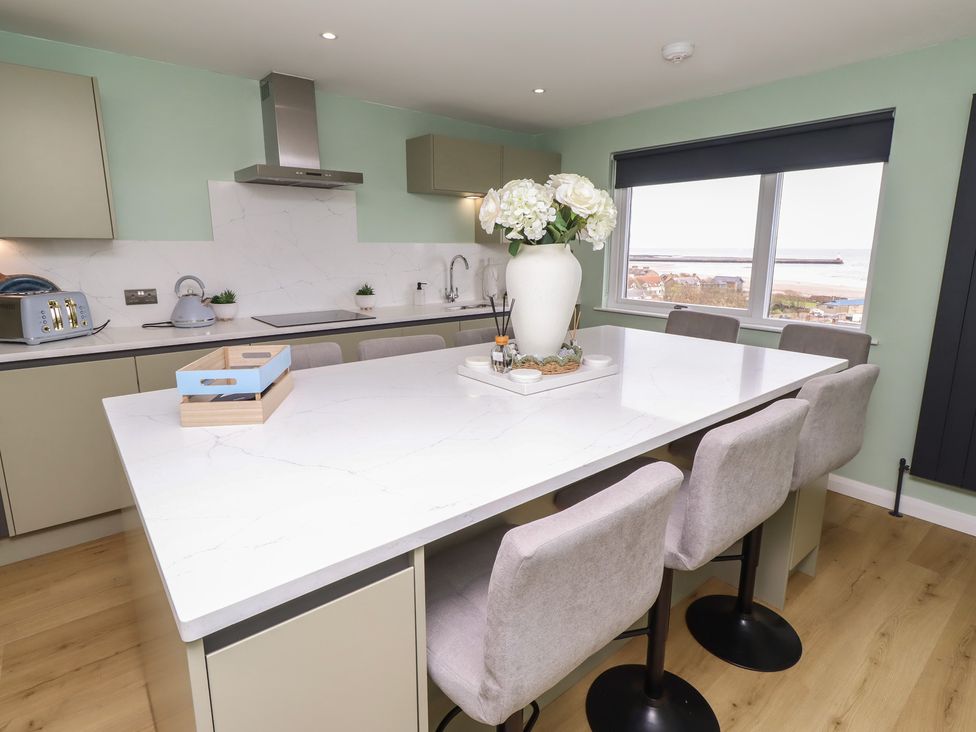 A kitchen featuring an island with bar stools at Tigh-Na-Mara Retreat