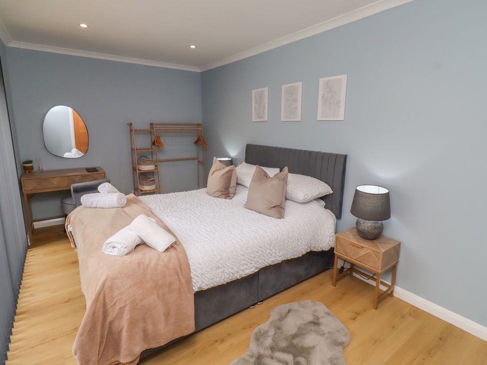 A bedroom with a bed, mirror, and dressing table at Tigh-Na-Mara Retreat 