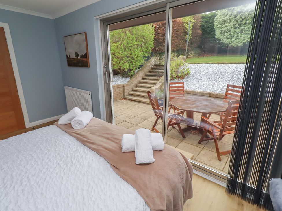 A bedroom with a view of an outdoor patio area at Tigh-Na-Mara Retreat 
