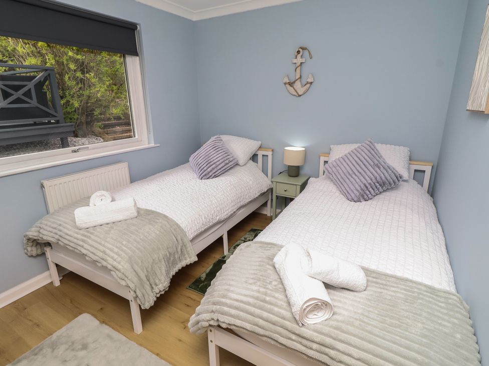 A bedroom with two beds and a lamp at Tigh-Na-Mara Retreat