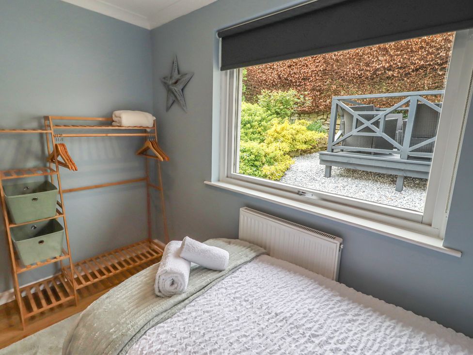 A bedroom with a bed and storage shelves at Tigh-Na-Mara Retreat