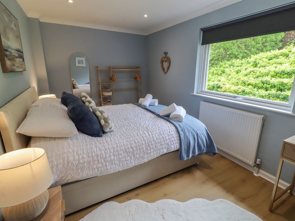 A bedroom with a bed and mirror at Tigh-Na-Mara Retreat