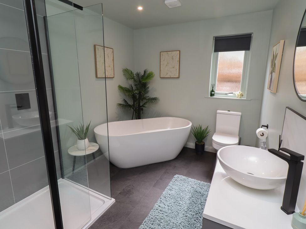 A bathroom with a bathtub, toilet, sink, and shower at Tigh-Na-Mara Retreat