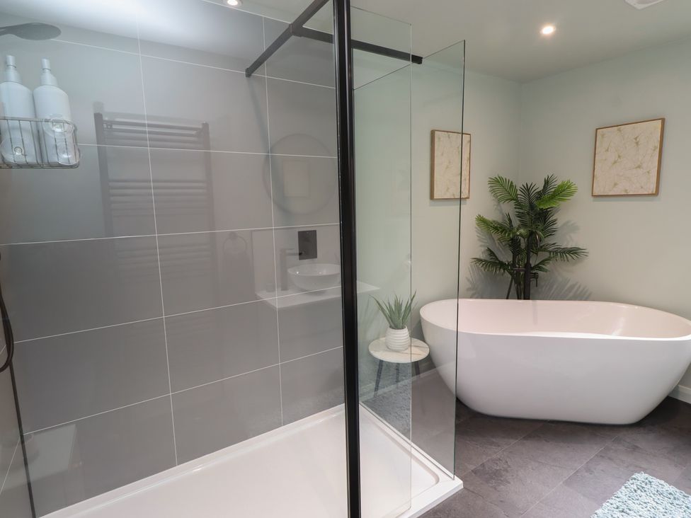 A bathroom with a shower, bathtub, sink, and towels at Tigh-Na-Mara Retreat