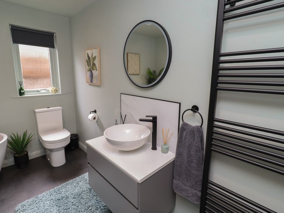 A bathroom with a toilet, wash basin and plants at Tigh-Na-Mara Retreat