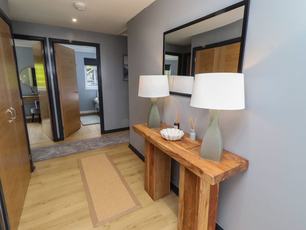 A hallway with a console table and lamps at Tigh-Na-Mara Retreat