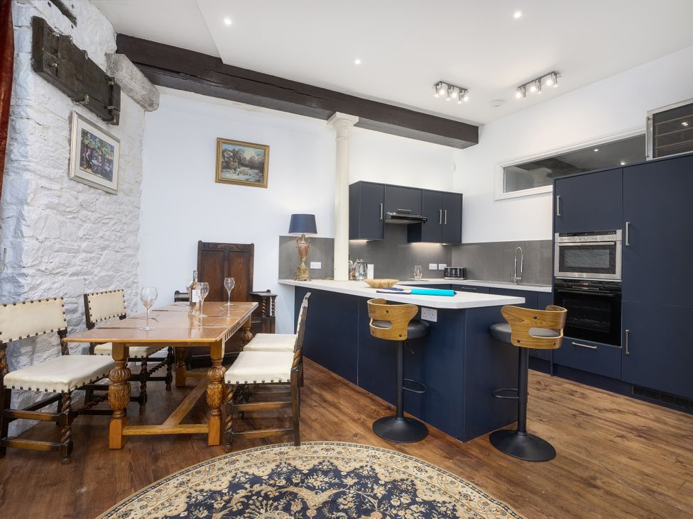 A kitchen with a dining table and bar stools at The Mayflower in Plymouth