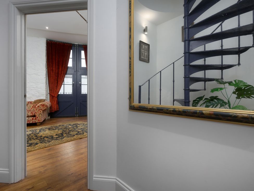 An entrance hall with a staircase and a sofa at The Mayflower in Plymouth