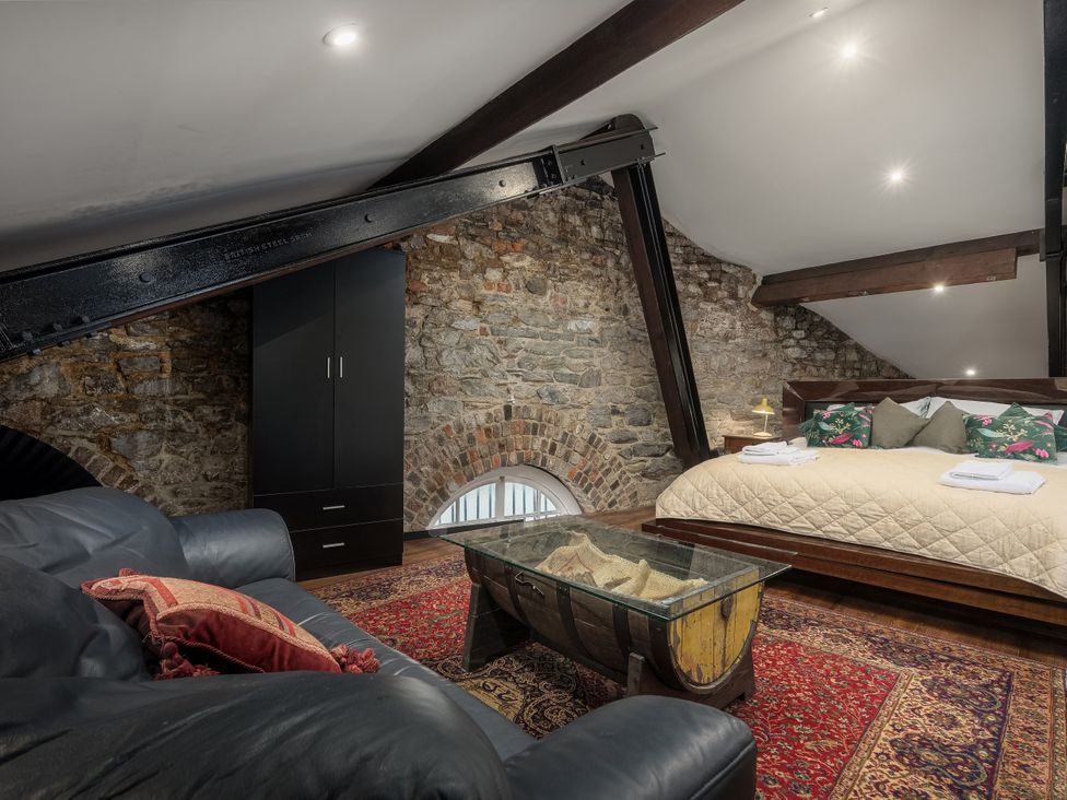 A bedroom with a bed, sofa, and coffee table at The Mayflower in Plymouth