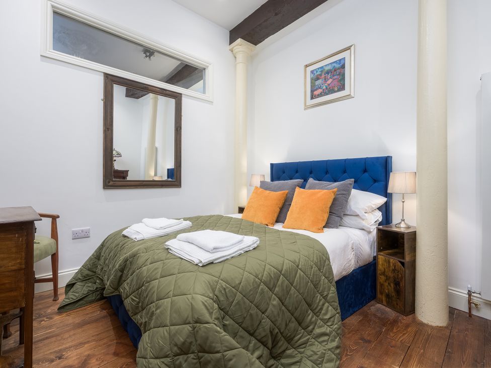 A bedroom with a bed, mirror, and chair at The Mayflower in Plymouth