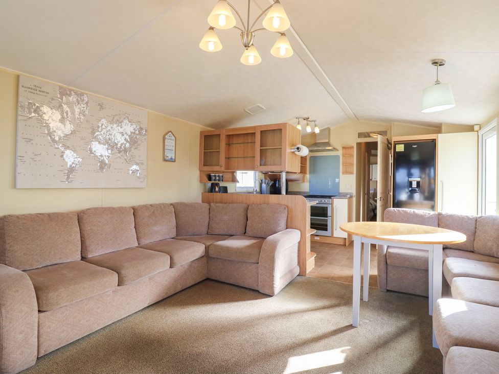 A living room with a sofa and table at Ocean Breeze Escape in Allhallows