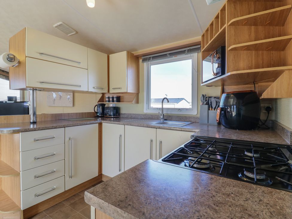 A kitchen with sink and gas stove at Ocean Breeze Escape, Allhallows
