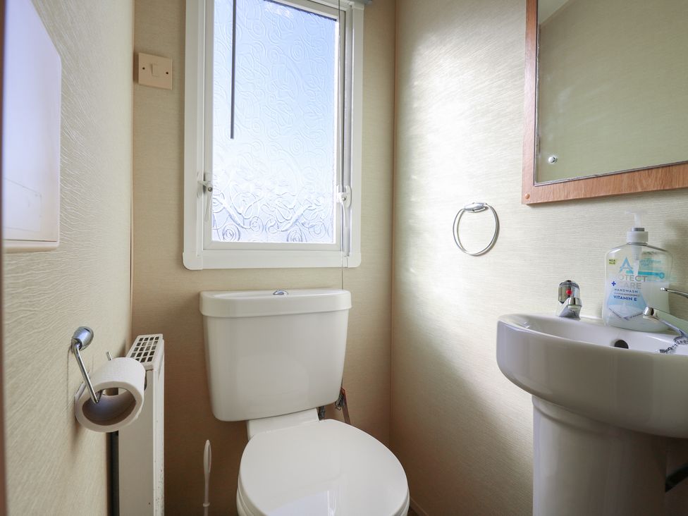 A bathroom with a toilet and sink at Ocean Breeze Escape in Allhallows
