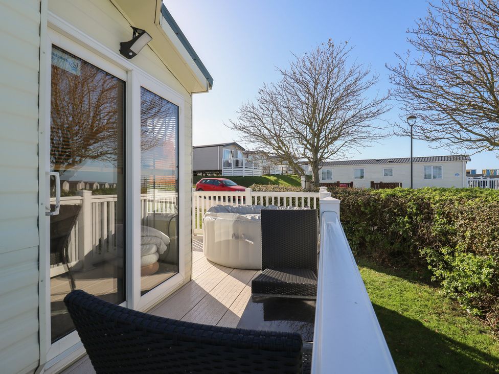 An outdoor area with chairs and a hot tub at Ocean Breeze Escape in Allhallows