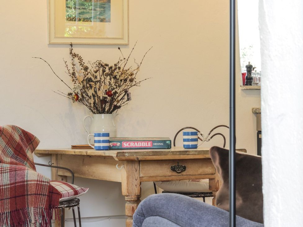 A dining room with a table and flowers at The Old Studio in Penzance