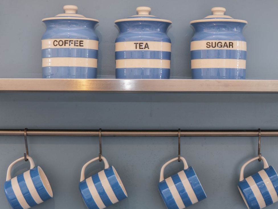 A kitchen with striped containers and mugs at The Old Studio in Penzance