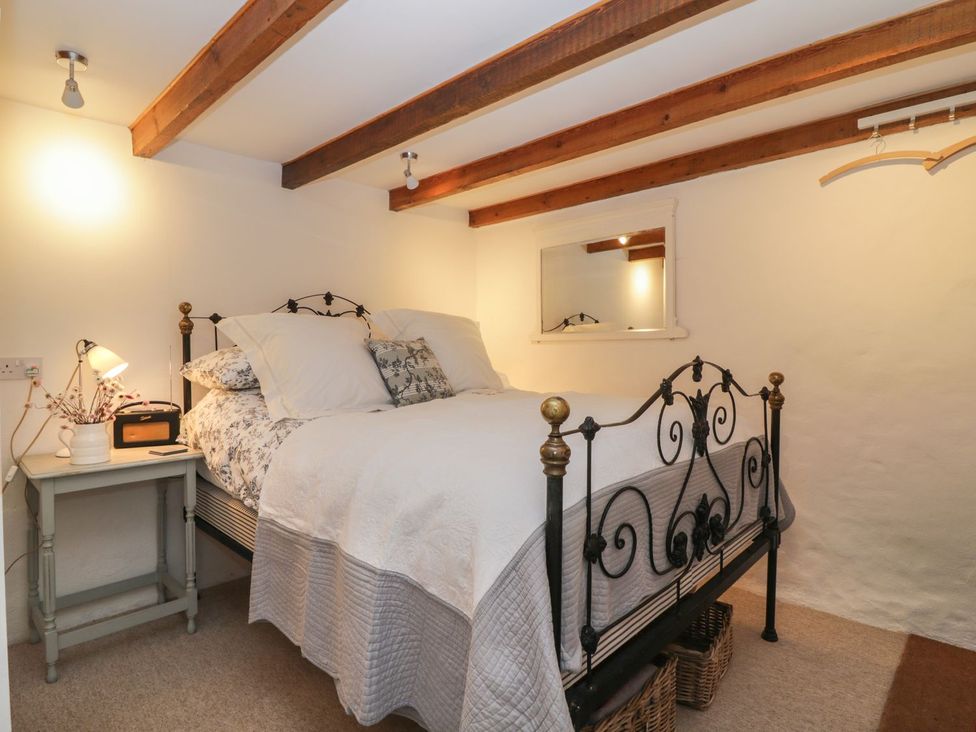 A bedroom with a bed and nightstand at The Old Studio in Penzance