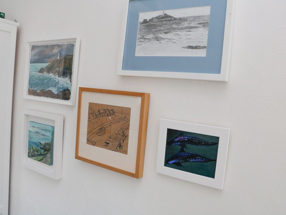 A collection of framed artwork on a wall at The Old Studio in Penzance