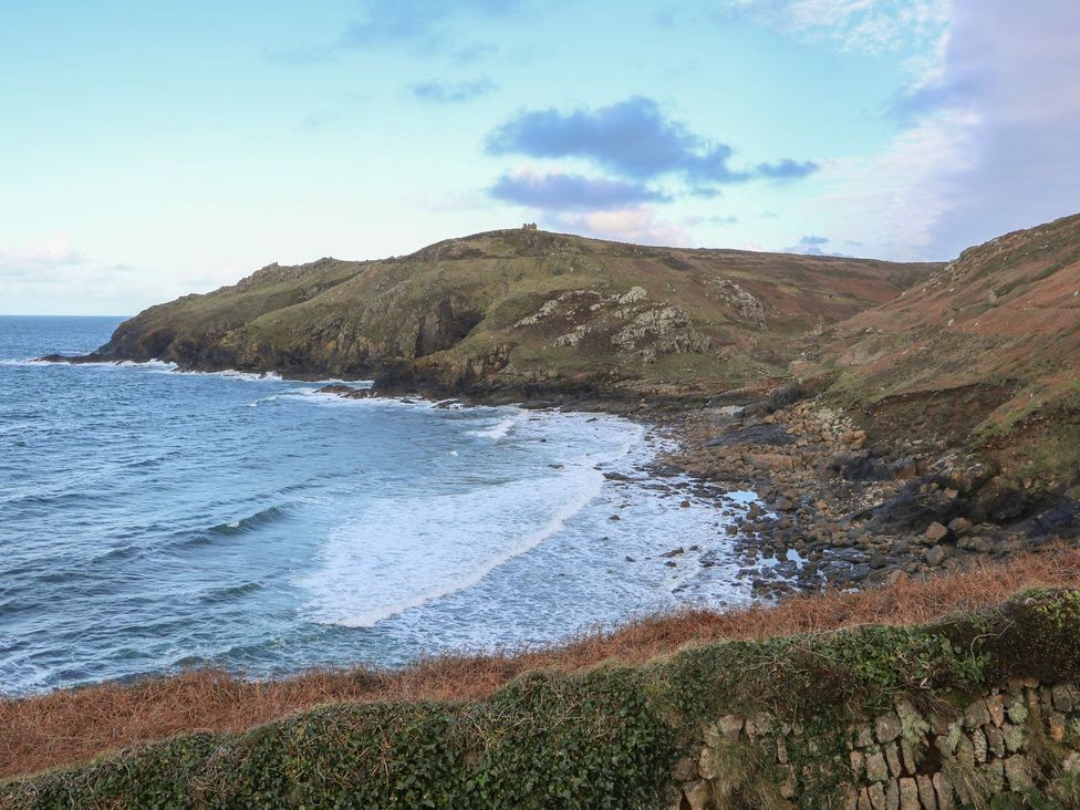 A coastline with waves and a hill at The Old Studio in Penzance