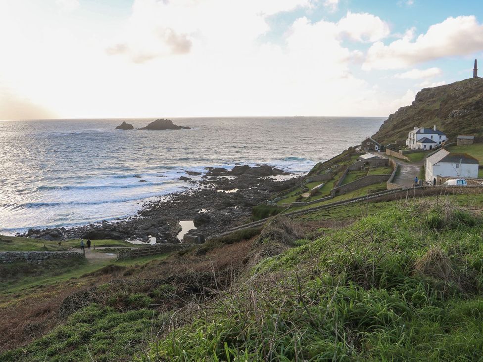 A coastal view with rocks and houses at The Old Studio in Penzance