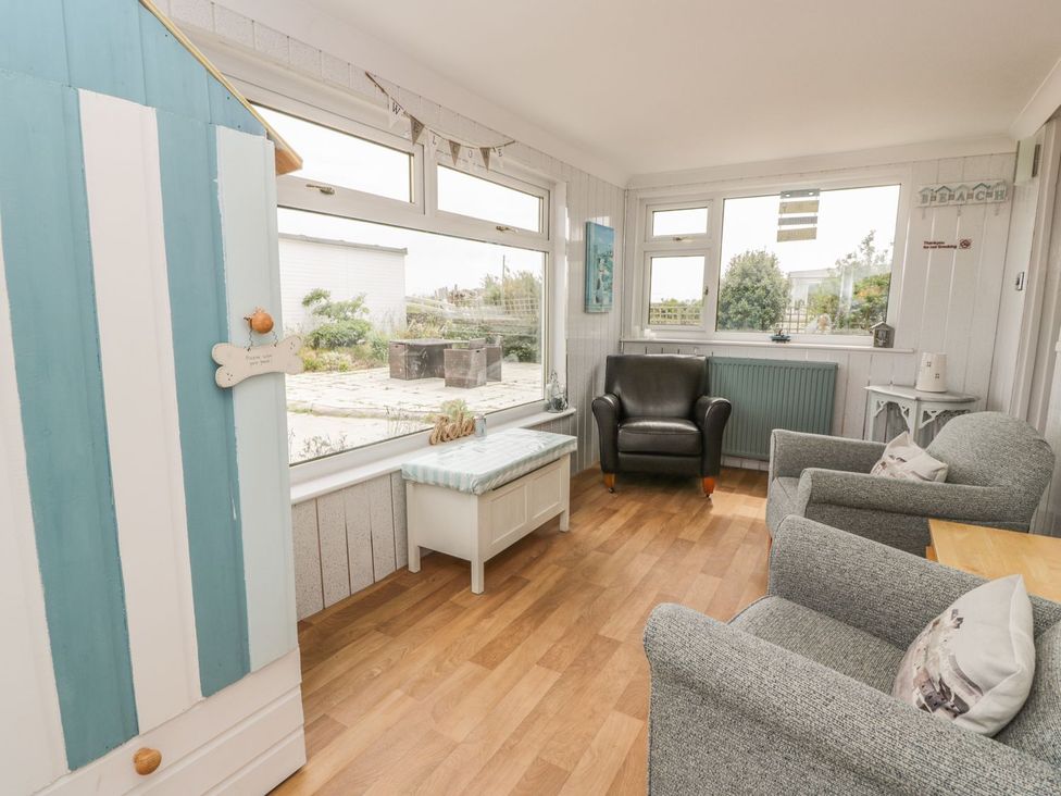 A conservatory with seating and a table at Wagtail Cottage 