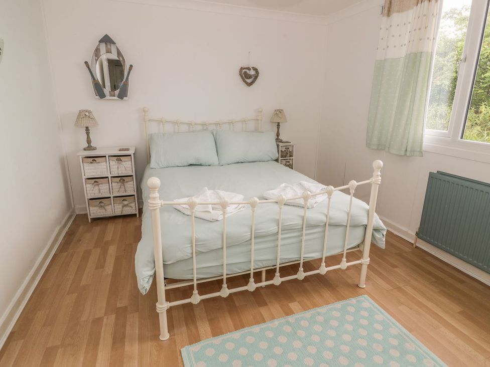 A bedroom with a bed and nightstand at Wagtail Cottage