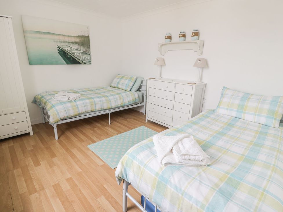 A bedroom with two beds and a dresser at Wagtail Cottage