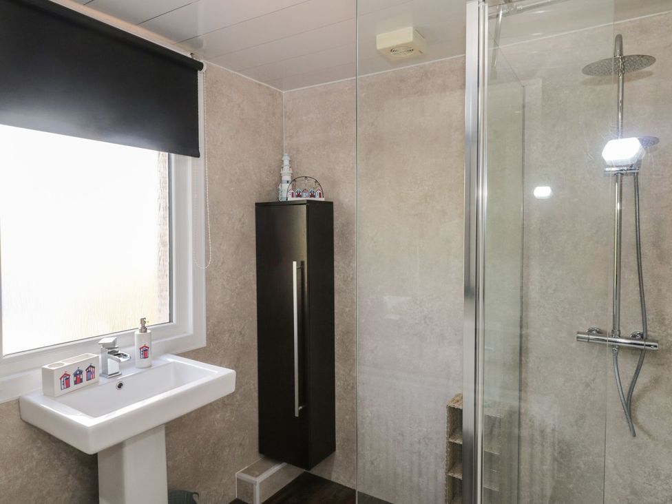 A bathroom with a washbasin and shower at Wagtail Cottage