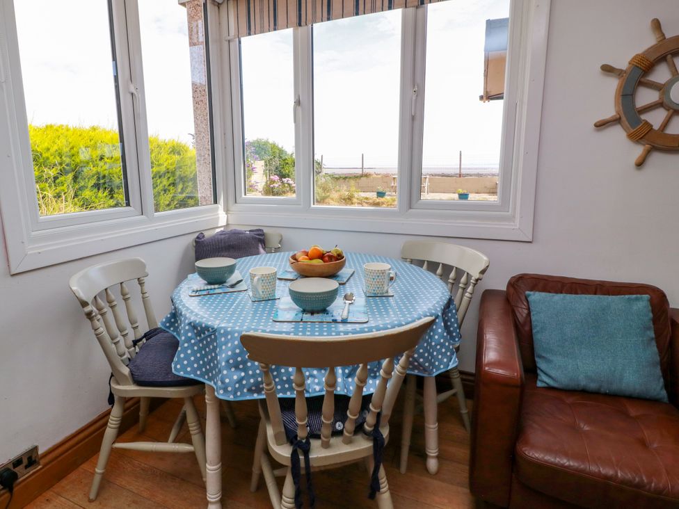 A dining area with a table and chairs at Wagtail Cottage in Southerness