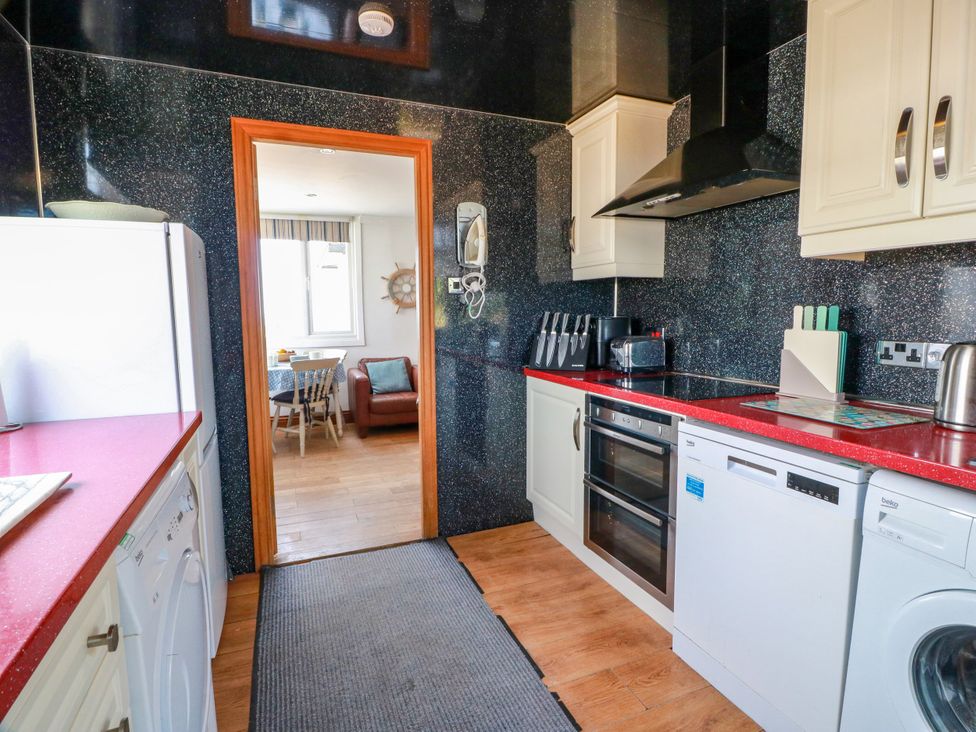 A kitchen with appliances and countertop at Wagtail Cottage in Southerness