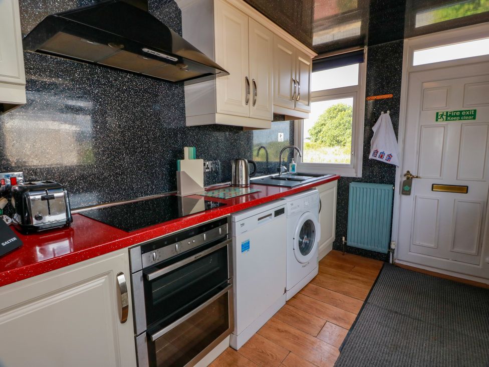 A kitchen with appliances and sink at Wagtail Cottage in Southerness