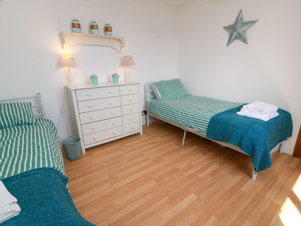 A bedroom with two beds and a dressing table at Wagtail Cottage Southerness