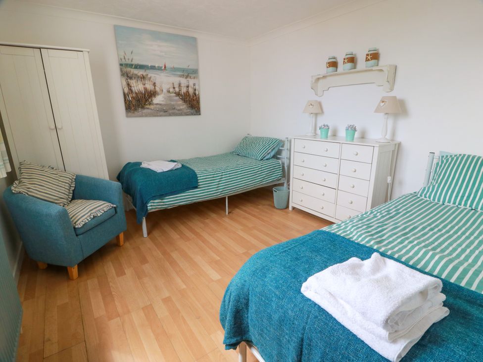 A bedroom with two single beds and a dresser at Wagtail Cottage in Southerness