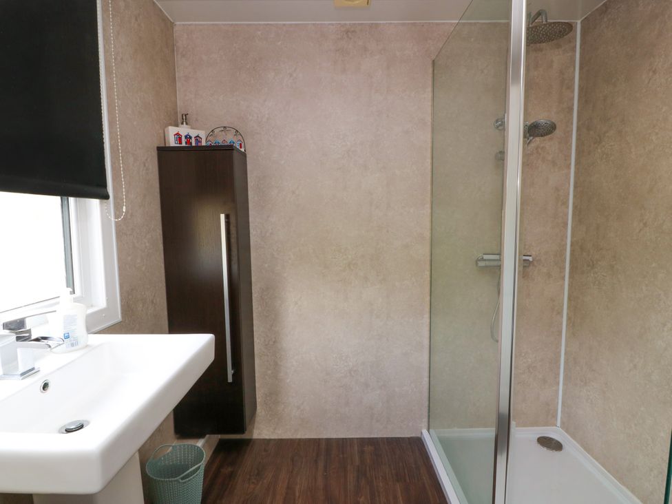 A bathroom with a sink and shower at Wagtail Cottage in Southerness